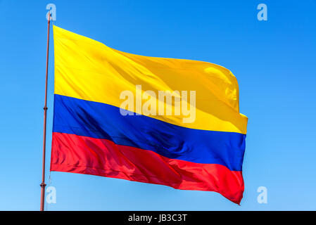 Splendente bandiera colombiana sventolare nel vento insieme contro un bel cielo azzurro Foto Stock