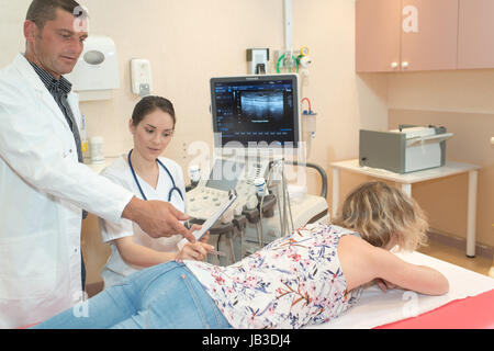 Medico e infermiere verifica su paziente di sesso femminile con problemi di schiena Foto Stock