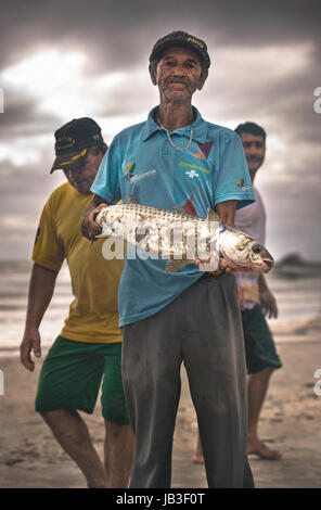 Ilha do Mel, Paraná, Brasile - 3 Giugno 2017: pescatore nativo di Ilha do Mel (Isola del Miele), tenendo un cefalo. Foto Stock