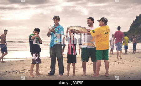 Ilha do Mel, Paraná, Brasile - 3 Giugno 2017: Native dei pescatori di Ilha do Mel (Isola del Miele) tenendo il pesce per la foto. Foto Stock