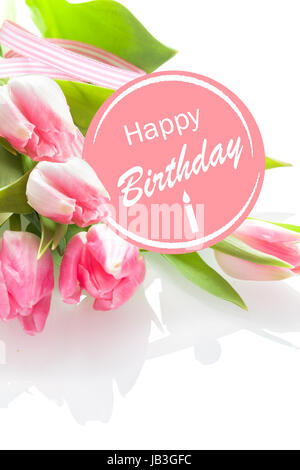 Piuttosto femminile Buon Compleanno messaggio di saluto con un festoso rosetta rosa e un mazzo di bella fresca tulipani rosa su sfondo bianco, closeup prospettiva Foto Stock