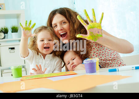 Ritratto di una famiglia felice avendo divertimento pittura con palme e dita Foto Stock