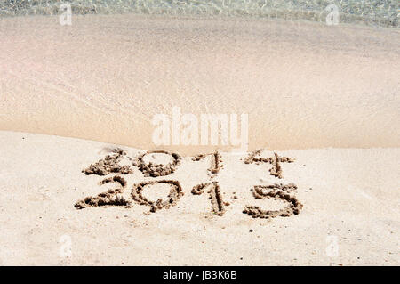 Anno Nuovo 2015 è venuta concetto - iscrizione 2014 e 2015 su una spiaggia di sabbia, l'onda sta iniziando a coprire le cifre 2014 Foto Stock