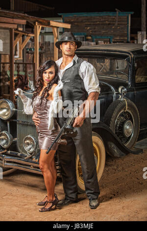 Bello muscoloso 1920s i gangster con lady in mini gonna Foto Stock