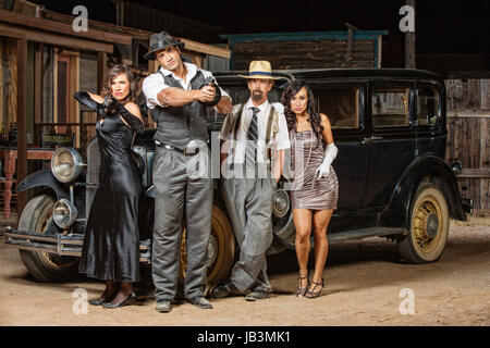 Gruppo misto di 1920s vintage gangster al di fuori Foto Stock