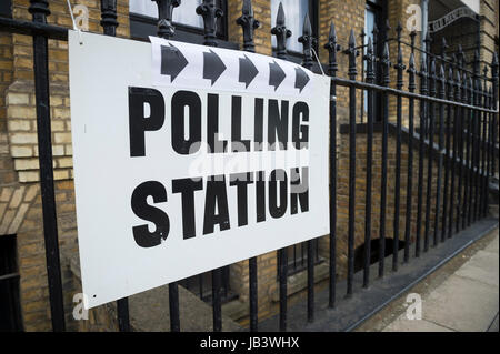 Elezioni britanniche stazione di polling segno appeso sulla porta post accanto a una siepe verde nel Regno Unito Foto Stock