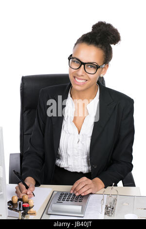 Junge hübsche, Büroangestellte sitzt am Schreibtisch im Büro und"führt Berechnungen Mit einem Tischrechner durch Foto Stock