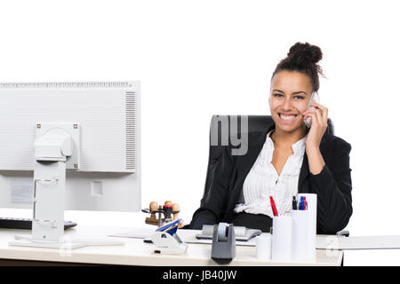 Junge hübsche, Büroangestellte sitzt am Schreibtisch im Büro und telefoniert Mit einem Smartphone Foto Stock