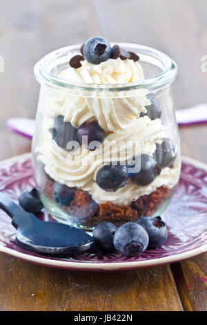 Cremiges Dessert in Schichten mit frischen Blaubeeren Foto Stock