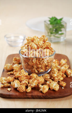 Ciotola di vetro di popcorn rivestita con caramello Foto Stock