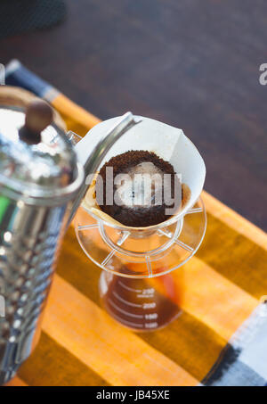 Versare il caffè infusore antigoccia con filtro di carta mentre il caffè fioritura Foto Stock