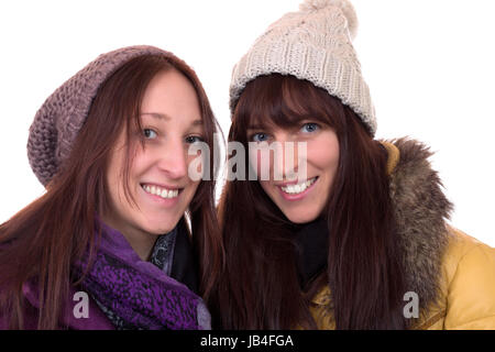 Zwei junge Frauen im Winter mit Mütze und Schal, isoliert vor einem weissen Hintergrund Foto Stock