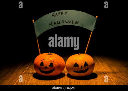 Due jack o'lanterna mandarini azienda happy Halloween segno Foto Stock