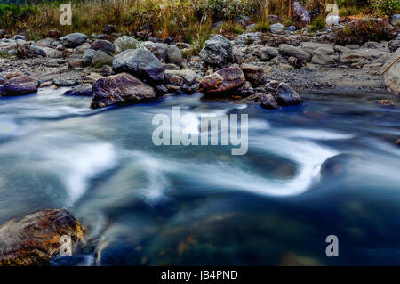 Reshi acqua di un fiume che scorre sulle rocce al tramonto, il Sikkim, India. Foto Stock