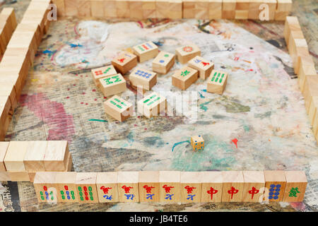 Giocando nel banco di mahjong gioco dalle tegole di legno sul tavolo squallido Foto Stock