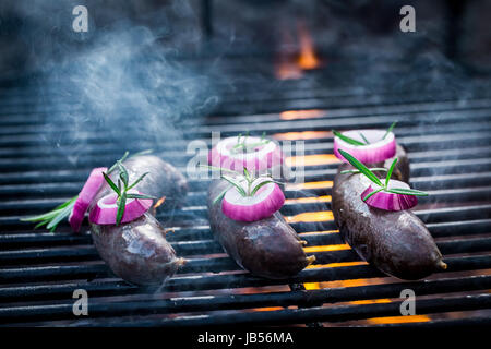 Black Pudding con rosmarino e cipolla sulla griglia Foto Stock