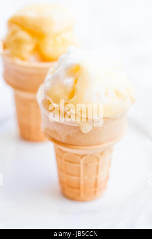 Primo piano dei due coni di gelato al mango su sfondo chiaro Foto Stock