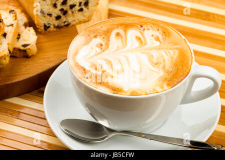 Tazza di cappuccino e torte su sfondo di legno Foto Stock