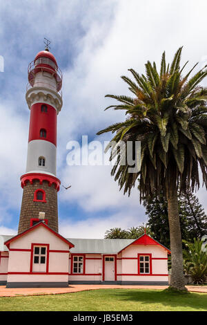 Rosso Bianco faro, e Palm tree, Swakopmund, Tedesco città coloniale, Namibia Foto Stock