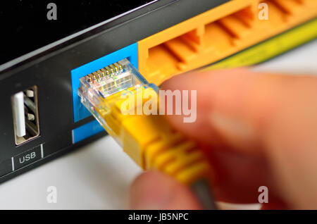 Il collegamento spina di rete sul router Foto Stock