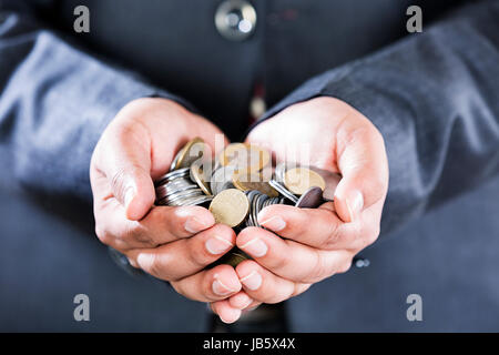 1 imprenditore a mani cupped holding coin denaro prestito lotteria sezione mediana Foto Stock