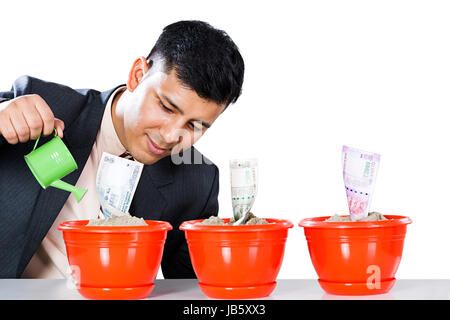 1 imprenditore denaro pianta in vaso l'innaffiamento può versare acqua di piantare la pianificazione futura Foto Stock