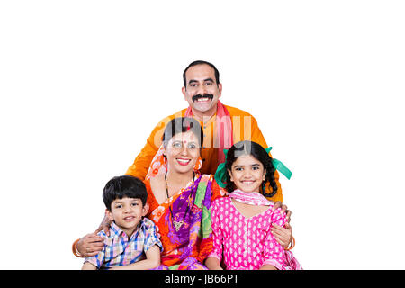 Felice indiano famiglia rurale- genitori con 2 bambini seduti insieme in Studio shot su sfondo bianco Foto Stock