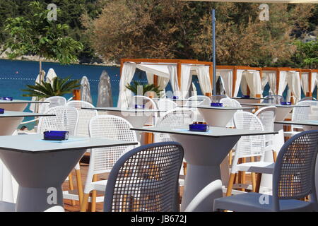 Idilliaco ristorante sulla spiaggia con tavoli bianchi e tettoie in Marjan vicino a Spalato, Croazia Foto Stock