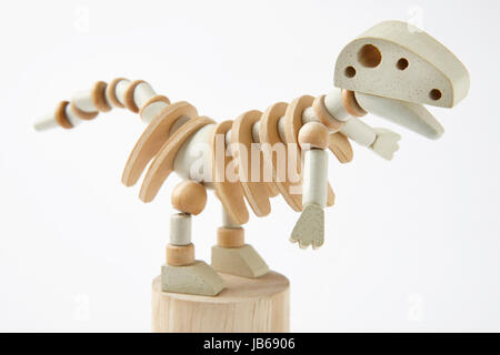 Dinosauro in legno giocattolo articolato isolato su bianco. Posizione orizzontale Foto Stock