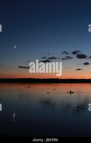 Bellissimo tramonto riflesso sul lago in Azur, in Francia con il cielo stellato di notte e chiari di luna Foto Stock