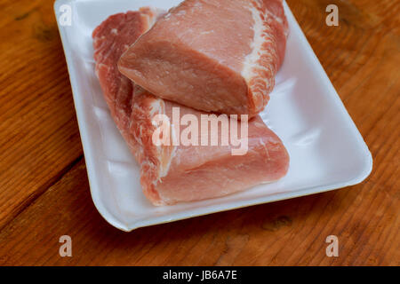 La carne cruda di filetti di maiale sul tagliere pronto per cucinare, filetto di maiale condimenti per la carne di maiale in legno marrone dello sfondo. Foto Stock