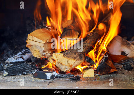 Masterizzazione e incandescente di pezzi di legno nel camino Foto Stock