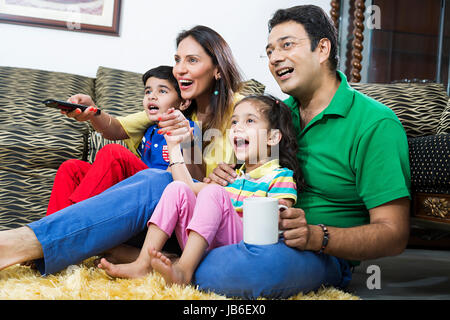 4 persone boy girl i bambini i genitori seduta sorridente tè guardare la televisione Foto Stock