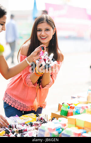 2 giovani ragazze Acquisto di abbondanza Nail Polish Shopping Fiera di stallo Foto Stock