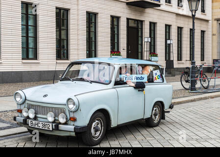 Berlino, Germania - 12 Aprile 2017: auto di Trabant brand con il suo driver nella parte anteriore della porta di Brandeburgo chiamato Trabi Andy piena di orsacchiotti a Berlino, G Foto Stock