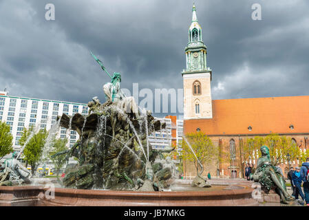 Berlino, Germania - 13 Aprile 2017: le persone camminare intorno alla fontana di Nettuno (Neptunbrunnen) con il St Mary Church (Marienkirche) in background in un Foto Stock