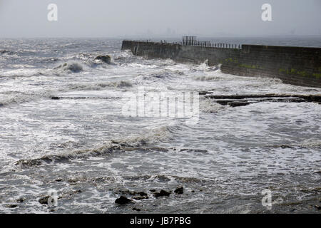 Onde che si infrangono contro la scogliera Heugh sul promontorio a Hartlepool su un grigio opaco giorno Foto Stock