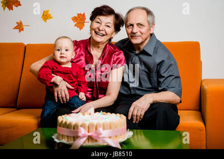 Nonni con il loro piccolo nipote celebrare la prima festa di compleanno a casa Foto Stock