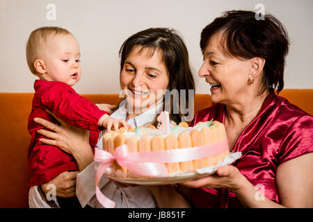 Madre e nonna con bimbo piccolo celebrando primo compleanno Foto Stock