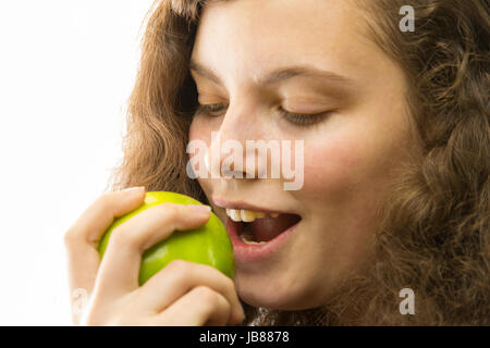 Eine junge hübsche Frau beisst in einen Apfel Foto Stock
