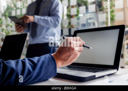 Il concetto di business. La gente di affari discutendo le tabelle e grafici che mostrano i risultati del loro lavoro di squadra di successo. Foto Stock