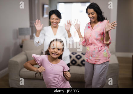 Ritratto di ragazza sorridente ballando con la famiglia a casa Foto Stock