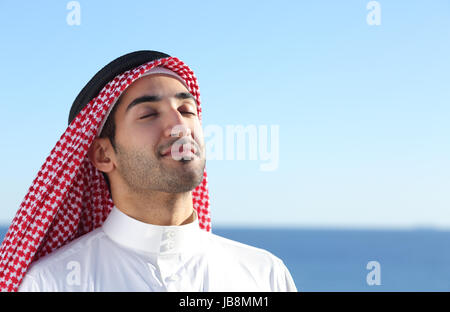 Arab arabia uomo respirazione profonda aria fresca in spiaggia con l'oceano e orizzonte in background Foto Stock