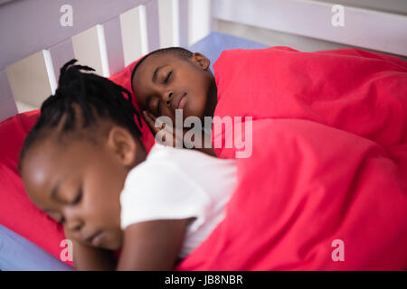 Angolo di Alta Vista del fratello e sorella dorme sul letto di casa Foto Stock