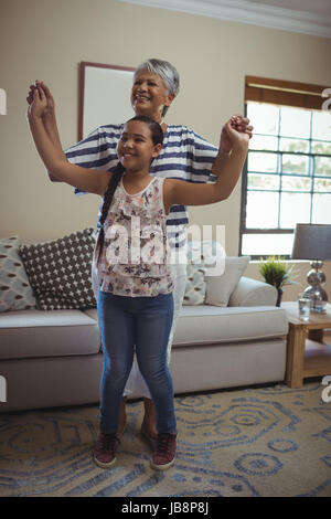 Nonna e nipote divertendosi nel salotto di casa Foto Stock
