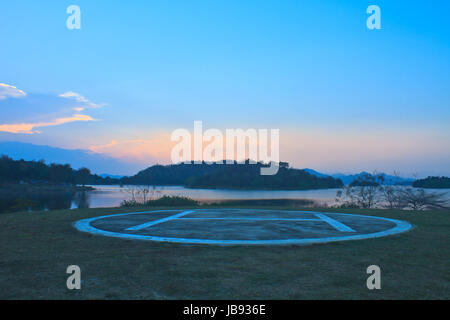 Zona di atterraggio elicotteri per elicottero parcheggio nei pressi del lago sul tramonto Foto Stock