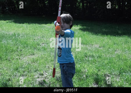 Biondo ragazzo europeo con un inchino in natura Foto Stock