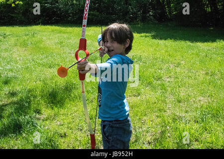 Biondo ragazzo europeo con un inchino in natura Foto Stock