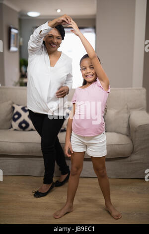 Ritratto di ragazza sorridente ballando con la nonna a casa Foto Stock