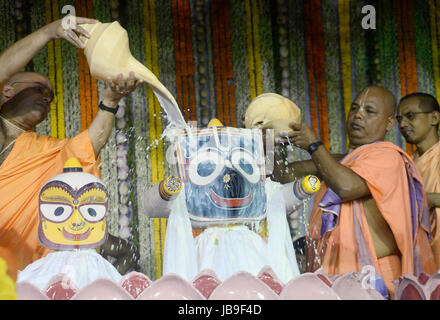 Kolkata, India. 09 Giugno, 2017. Società internazionale per la Coscienza di Krishna (ISKCON) il sacerdote e il Sanyasi o santo uomo versare il latte, miele, latticini e acqua Jagannath, Balabhadra sul Signore Jagannath, Balabhadra e Subhadra in occasione del Snan Yatra o cerimonia di balneazione davanti a loro Ratha Yatra o carro il festival in Kolkata. Credito: Saikat Paolo/Pacific Press/Alamy Live News Foto Stock